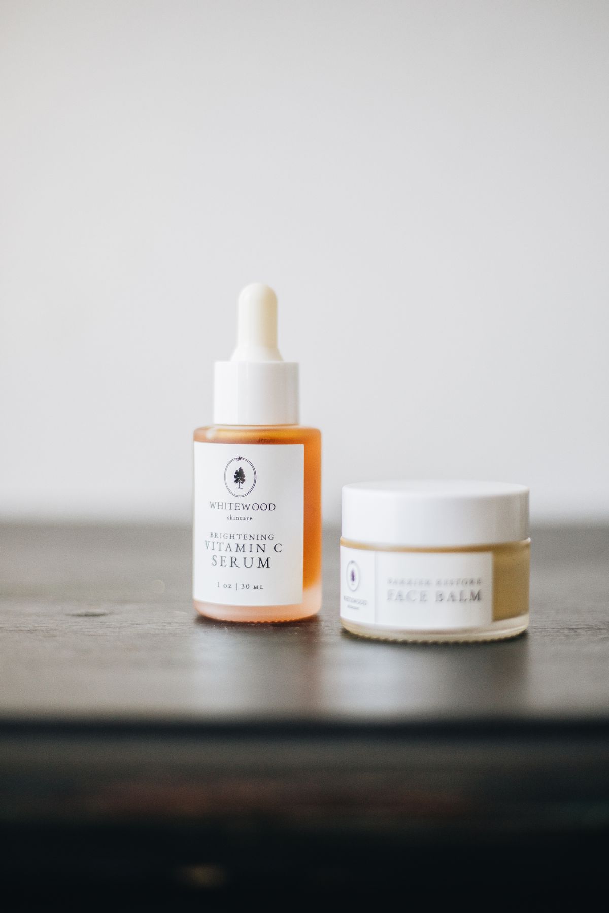 Vitamina C vs niacinamida: fotografía editorial de composición editorial de productos cosméticos faciales en formato sérum y bálsamo