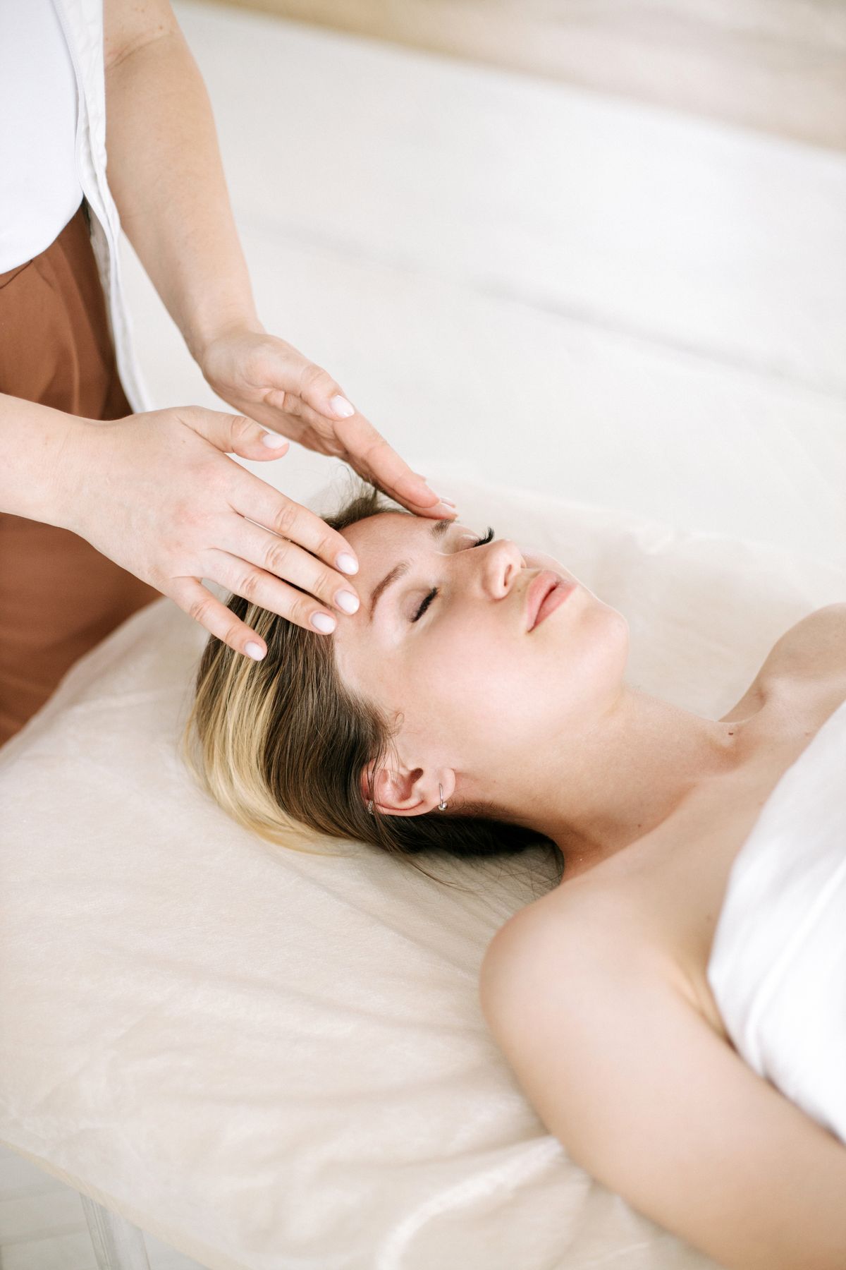 Masaje facial drenante: fotografía editorial de mujer recibiendo masaje facial manual en un contexto de spa