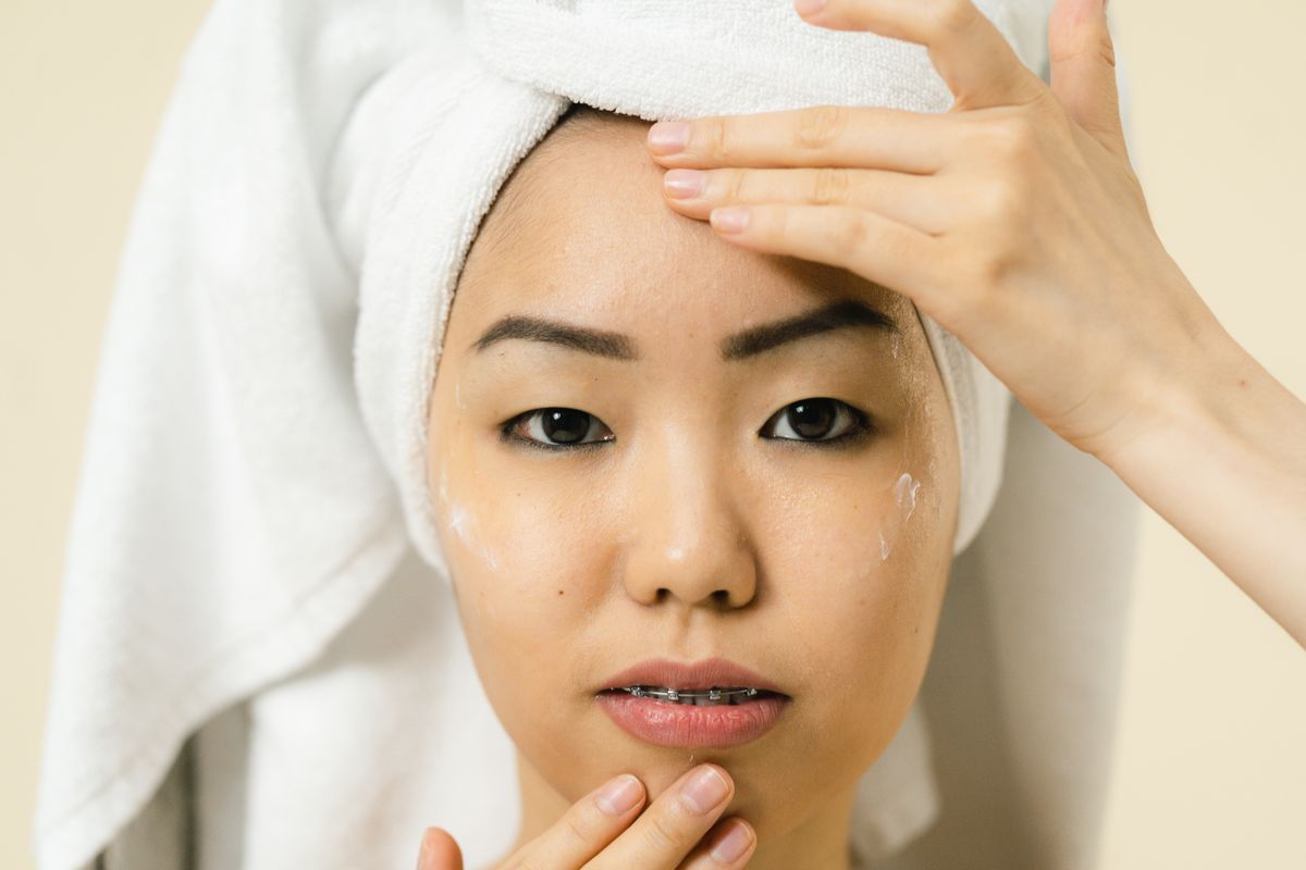 Rutina para principiantes: fotografía editorial de woman applying facial cream in a daily skincare routine